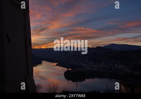 Panorama del lago di Mercatale, visto dalla piazza dell'orologio del paese di Sassocorvaro, contro un cielo scenografico al tramonto Banque D'Images