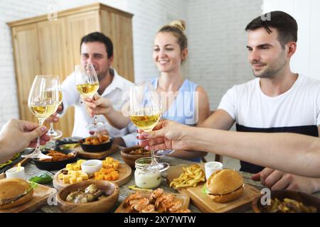 Les amis de vin blanc servi sur toast avec de la nourriture de table. L'amitié et de bonheur concept Banque D'Images