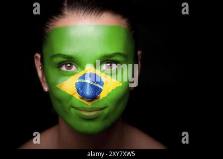 Portrait d'une femme avec le drapeau du Brésil peint sur son visage Banque D'Images