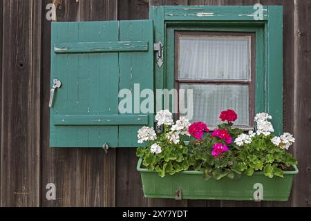 Petite fenêtre à une cabane de montagne avec géraniums Banque D'Images