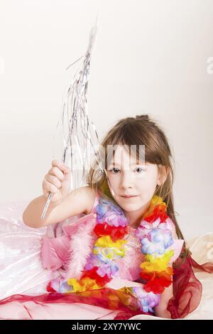 Petite fille joue à la fée dans un costume rose et une baguette magique Banque D'Images