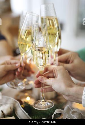 Groupe d'amis toasting with champagne tout en ayant le dîner de Noël. Close up Banque D'Images