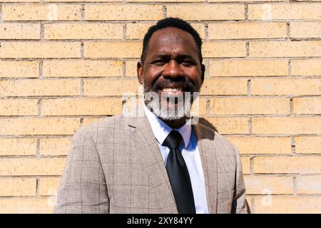 Homme d'affaires noir mature portant costume élégant se promenant dans la ville - homme senior adulte africain corporatif avec barbe grise Banque D'Images