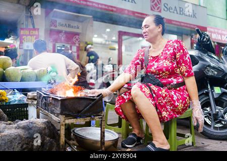 Hanoi, Vietnam - 9 novembre 2023 : une femme est vue cuisiner de la nourriture de rue dans les rues de Hanoi. L'économie vietnamienne est l'une des plus dynamiques Banque D'Images