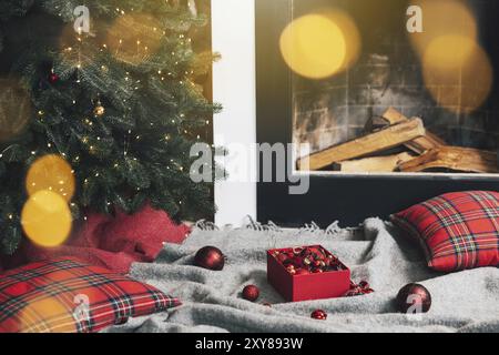 Boîte de boules de Noël posés sur le tapis gris ou le tissu prêt à l'emploi pour la décoration et la suspension sur le sapin de Noël vert avec des lumières, guirlande dans le Banque D'Images