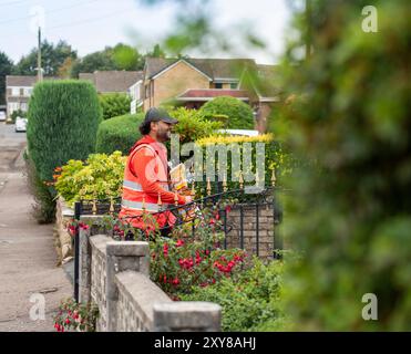 Un facteur effectue des livraisons dans le village de Northowram, dans le West Yorkshire, à Calderdale, au Royaume-Uni. Royal mail Group Limited, opérant sous le nom de Royal mail, est une société britannique de services postaux et de messagerie. Elle appartient à International distribution services. Elle exploite les marques Royal mail (lettres et colis) et Parcelforce Worldwide (colis). Crédit : Windmill images/Alamy Live News Banque D'Images