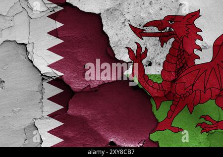 Drapeaux du Qatar et du pays de Galles peints sur un mur fissuré Banque D'Images