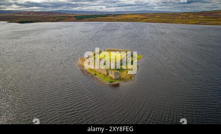 Lochindorb Loch à la fin de l'été le château médiéval de Lochindorb au centre du loch entouré de collines revêtues de bruyère violettes Banque D'Images