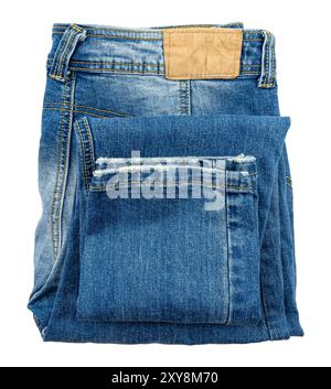 Jean bleu foncé plié sur fond blanc. Tissu. Les jeans isolent Banque D'Images