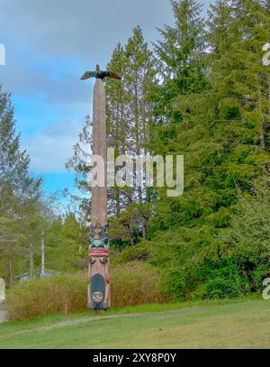 Totem avec aigle se trouve dans Saxman Totem Park, Ketchikan, Alaska.. Les Amérindiens Tlingit l'ont sculptée. L'aigle est au sommet du poteau. Ciel au-dessus. Banque D'Images