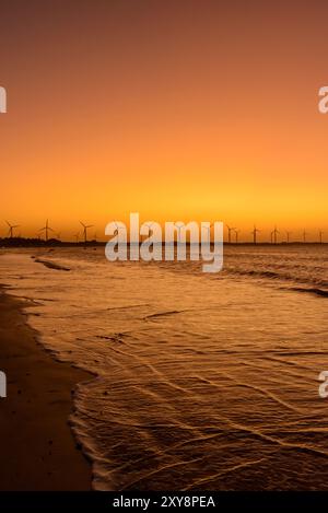 Énergie éolienne. Crépuscule après le coucher du soleil derrière le parc éolien sur la plage de Icaraí de Amontada, ce, Brésil, le 1er juillet 2024. Banque D'Images