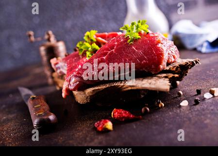 Viande crue aux herbes et à l'ail, viande de marbre. Fond en bois. Banque D'Images