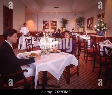 'Scène gastronomique rétro avec un intérieur aux couleurs vives, les clients, les modèles posent naturellement, soulignant l'ambiance sociale, confortable et nostalgique. Banque D'Images