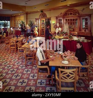 'Scène gastronomique rétro avec un intérieur aux couleurs vives, les clients, les modèles posent naturellement, soulignant l'ambiance sociale, confortable et nostalgique. Banque D'Images