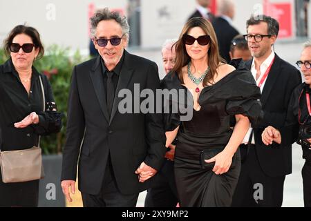 Venedig, Italie. 28 août 2024. Monica Bellucci, membre de la distribution du film d'ouverture, et son partenaire, Tim Burton, réalisateur du film, assistent à l'ouverture du 81e Festival International du film de Venise avec le film 'Beetlejuice Beetlejuice'. Crédit : Stefanie Rex/dpa/Alamy Live News Banque D'Images