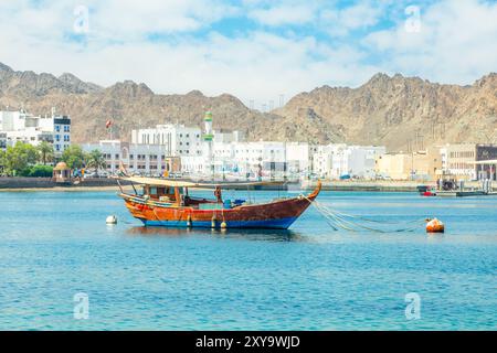 Panorama de la promenade de Mutrah avec chaîne de montagnes et golfe de mer avec ancré bateau traditionnel de boutre, Muscat, sultanat Oman Banque D'Images