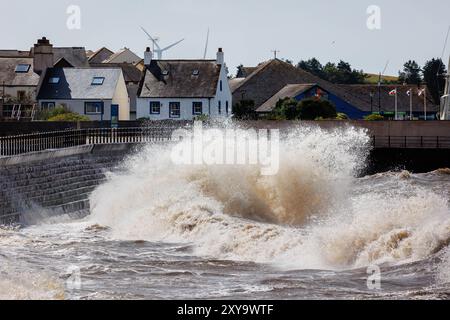 Des mers orageuses créant d'énormes vagues contre les marches à l'entrée du port de Maryport Banque D'Images