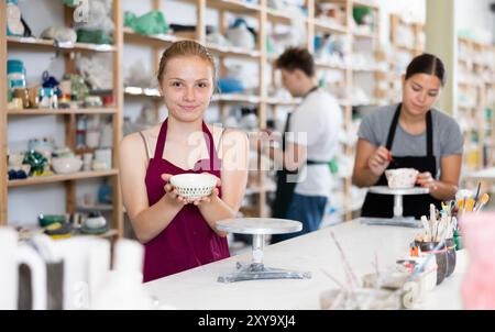 Jeune fille posant avec une tasse en céramique dans un atelier en céramique Banque D'Images