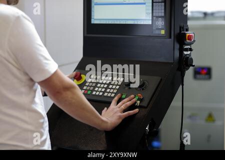 L'opérateur contrôle le centre d'usinage CNC industriel métallurgique. Console de commande de machine CNC. Mise au point sélective. Banque D'Images