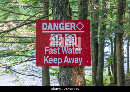 Panneau affiché près de Ragged Falls dans le parc provincial Oxongue River Ragged Falls avertissant les visiteurs des dangers du fst en mouvement de l'eau et de la natation divi Banque D'Images