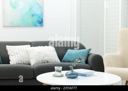 Table basse avec livres et décor près d'un canapé dans le salon, mise au point sélective Banque D'Images