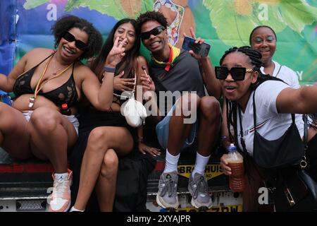 Les fêtards sourient à la caméra alors qu'ils se reposent à l'arrière d'un camion de musique au Carnaval de Notting Hill. Banque D'Images