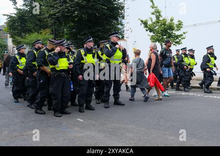 Les unités de police sont déplacées en position au carnaval de Notting Hill alors que 7 000 agents sont déployés lors de l'événement annuel célébrant la culture des Caraïbes. Banque D'Images