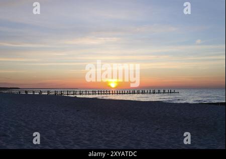 Au coucher du soleil, les groynes joyent dans la mer. Le soleil brille sur la mer Baltique. Paysage de la côte Banque D'Images