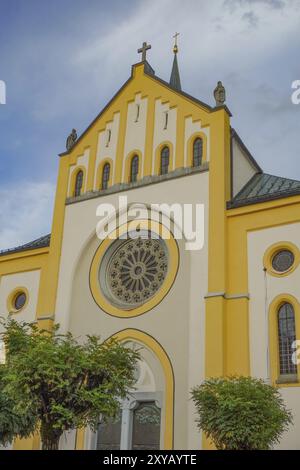 Façade jaune et blanche de l'église avec de grandes fenêtres et un ciel nuageux en arrière-plan, oberstaufen, allgaeu, bavière, allemagne Banque D'Images