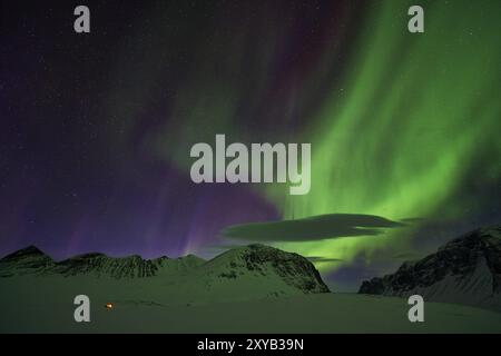 Aurores boréales (aurores boréales) sur tente illuminée, Stuor Reiaddavaggi, Kebnekaisefjaell, Norrbotten, Laponie, Suède, mars 2014, Europe Banque D'Images