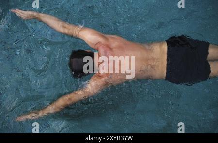 Jeune homme athlétique la natation dans la piscine Banque D'Images