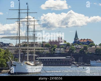 Grand voilier au port en face d'une ville avec des bâtiments historiques sous un ciel nuageux, stockholm, mer baltique, suède, scandinavie Banque D'Images