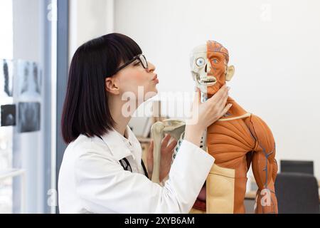 Étudiant en médecine examinant un mannequin anatomique en classe Banque D'Images