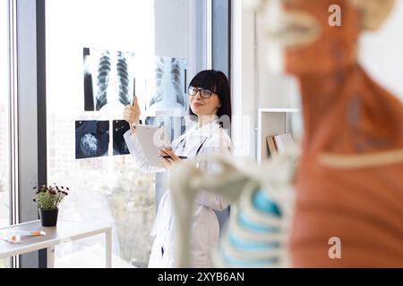 Médecin analysant les radiographies thoraciques au cabinet médical Banque D'Images