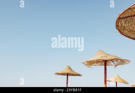 Vue sur un parasol en bois ou une cabane en chaume depuis le bas, avec une vue magnifique sur le ciel bleu ciel nuageux sur la plage tropicale de l'Égypte.Holida d'été ou d'hiver Banque D'Images