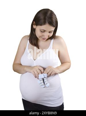 Souriante jeune femme enceinte avec chaussettes bébé rayé bleu Banque D'Images