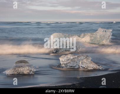 Icebergs du lac glaciaire Joekulsarlon sur la plage voisine de basalte noir Banque D'Images