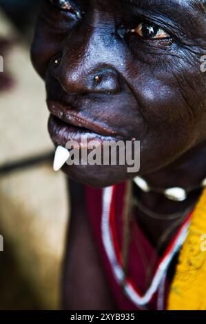 Une femme tribale avec une dent de sanglier insérée sur sa lèvre inférieure. Photo prise dans le nord du Togo. Banque D'Images