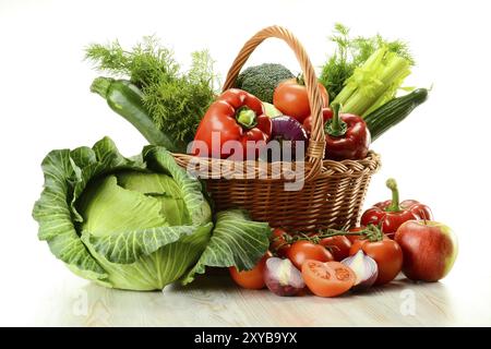 La composition avec des légumes crus et panier en osier isolated on white Banque D'Images