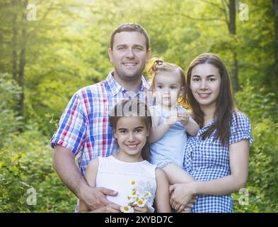 Heureux jeune famille avec deux enfants dans la forêt au printemps Banque D'Images