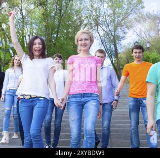 Groupe d'adolescents souriants la marche à l'extérieur. Concept d'amitié Banque D'Images