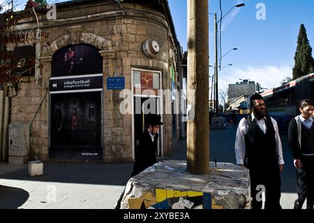 Hommes haredi marchant dans le quartier ultra-orthodoxe de Geula à Jérusalem, Israël. Banque D'Images