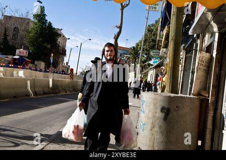 Hommes haredi marchant dans le quartier ultra-orthodoxe de Geula à Jérusalem, Israël. Banque D'Images