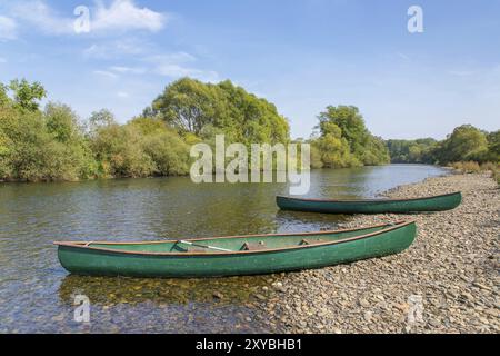 Deux canoës vert couché dans la rivière au bord de l'eau Banque D'Images