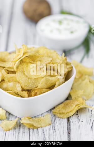 Croustilles de pommes de terre de crème sure (goût) sur fond de bois rustique (gros plan) Banque D'Images