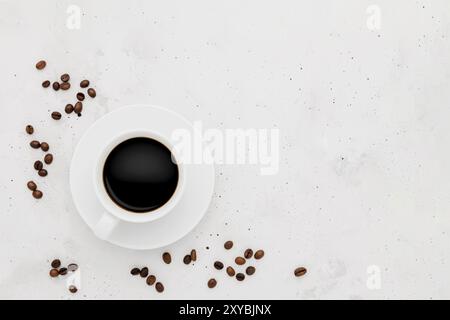 Vue de dessus sur une surface plane avec une seule tasse de café sur fond de béton blanc gris. Disposition de la collection de tasses à thé. Grains de café secs arou Banque D'Images