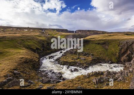 Rivière blanche coulant à travers la roche volcanique à Hengifoss en Islande Banque D'Images