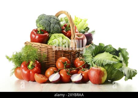 La composition avec des légumes crus et panier en osier isolated on white Banque D'Images