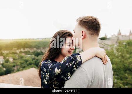 Jeune caucasien affectueux couple mature se relaxant pendant les activités de plein air, souriant, embrassant et embrassant. Traversez la route du parc national. Deux touris Banque D'Images