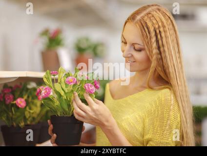 Young woman buying flowers dans un centre de jardinage. Les tons de couleur de l'image. Shallow DOF Banque D'Images